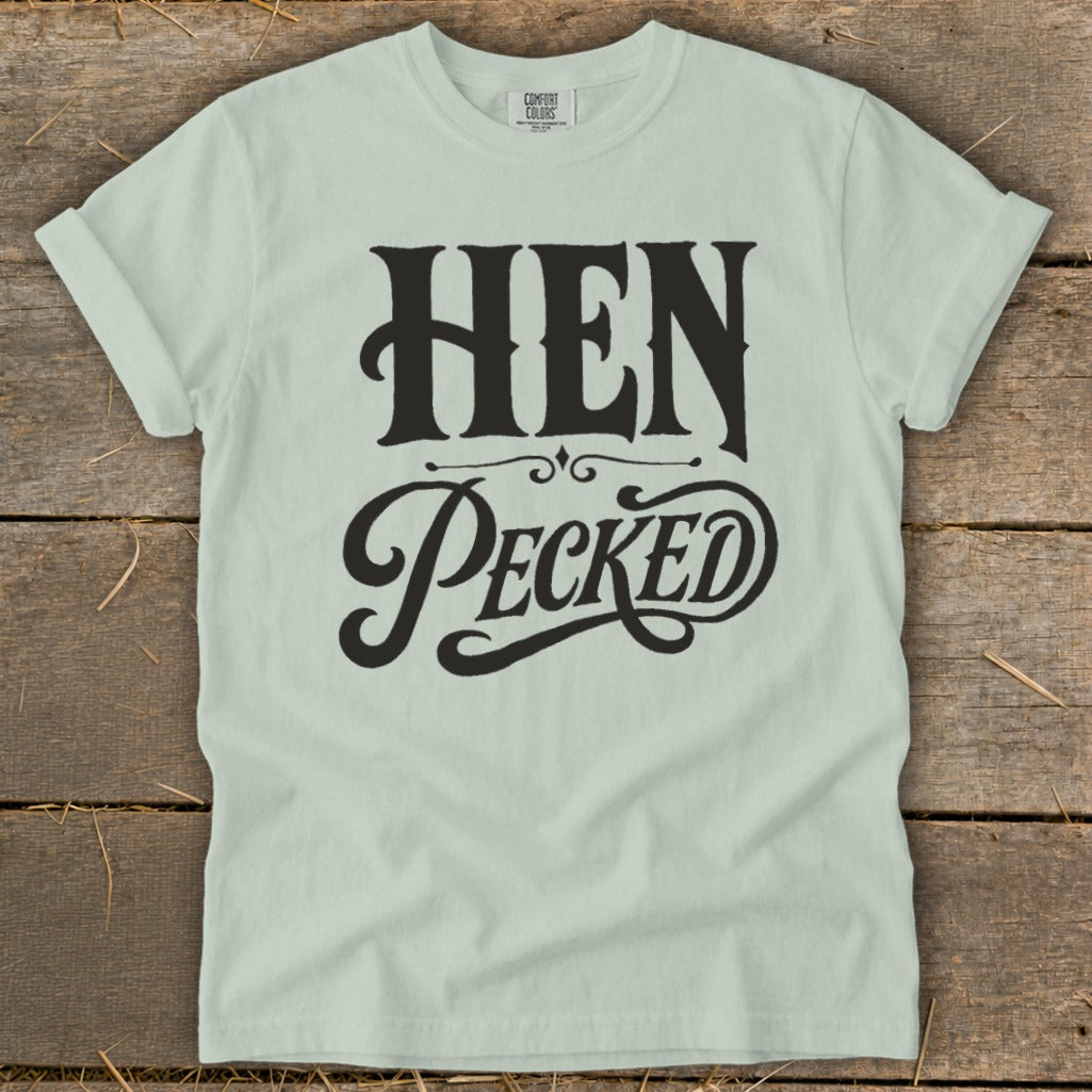 Light green t-shirt with black text that reads "HEN PECKED" in a decorative font.