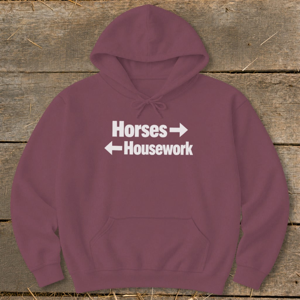 Maroon pullover hoodie with a front pocket, featuring white text that reads Horses with a right arrow and Housework with a left arrow.