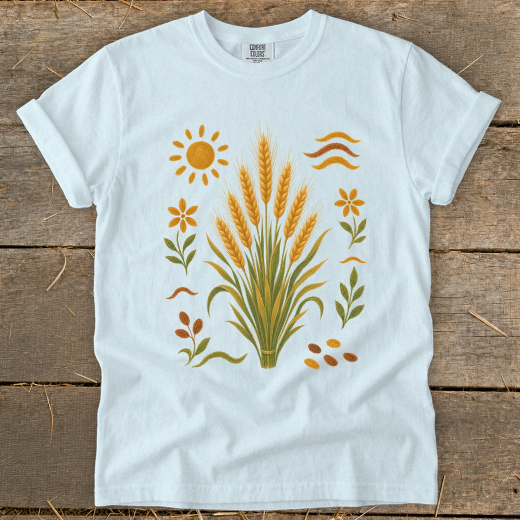 White t-shirt with a central wheat stalk design and sun, flowers, and leaves.