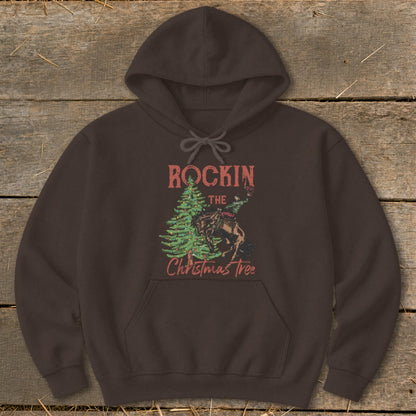 Brown hoodie with "Rockin the Christmas Tree" graphic of a cowboy riding a horse by a decorated tree.