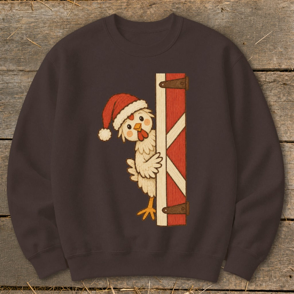 Chicken wearing Santa hat peeks from behind a red barn door.