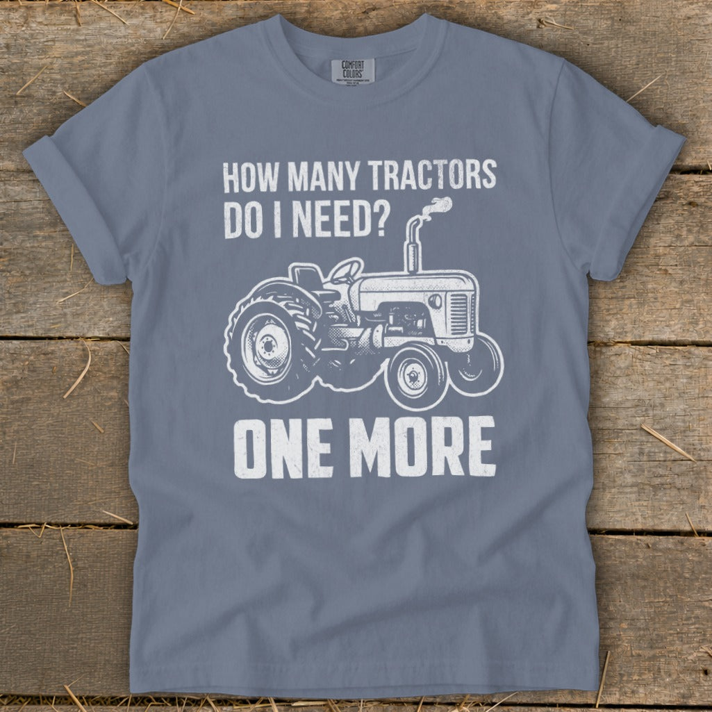 T-shirt with white graphic of a tractor and text: "How Many Tractors Do I Need? One More".