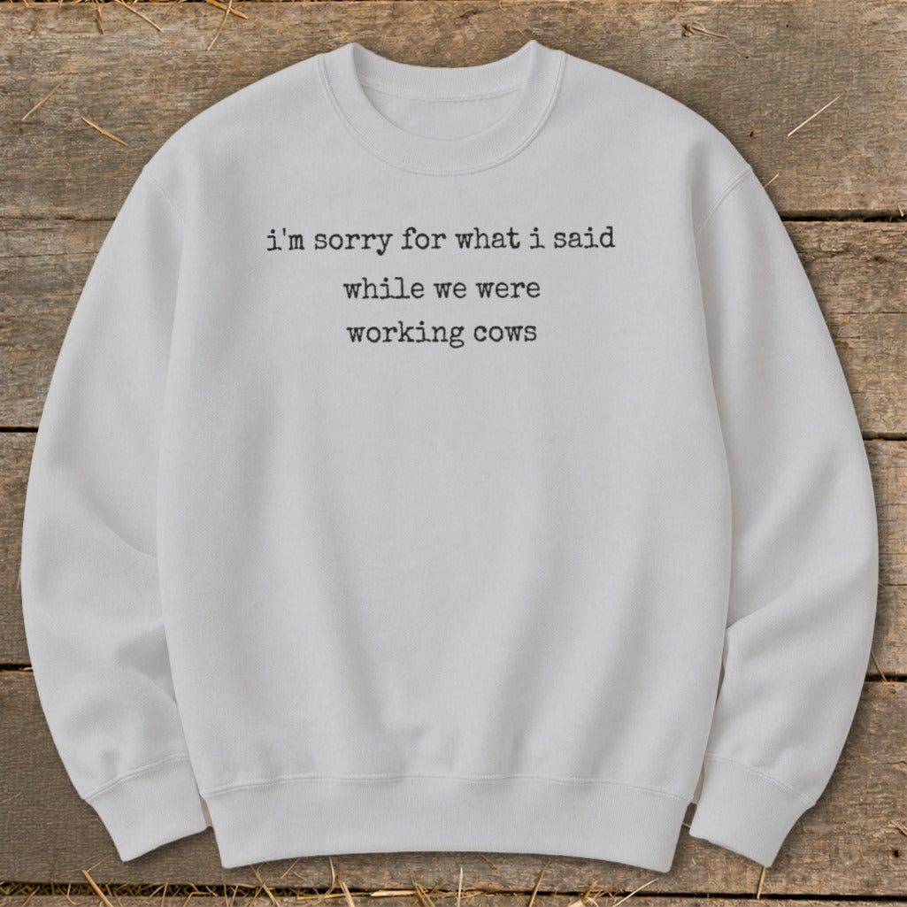 Light gray sweatshirt with text "i'm sorry for what i said while we were working cows".