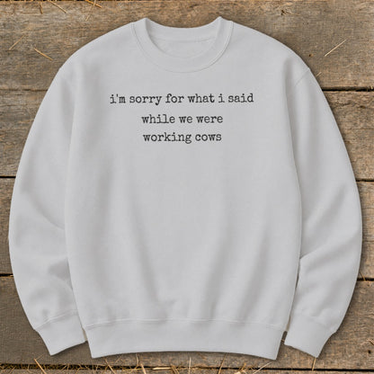 Light gray sweatshirt with text "i'm sorry for what i said while we were working cows".