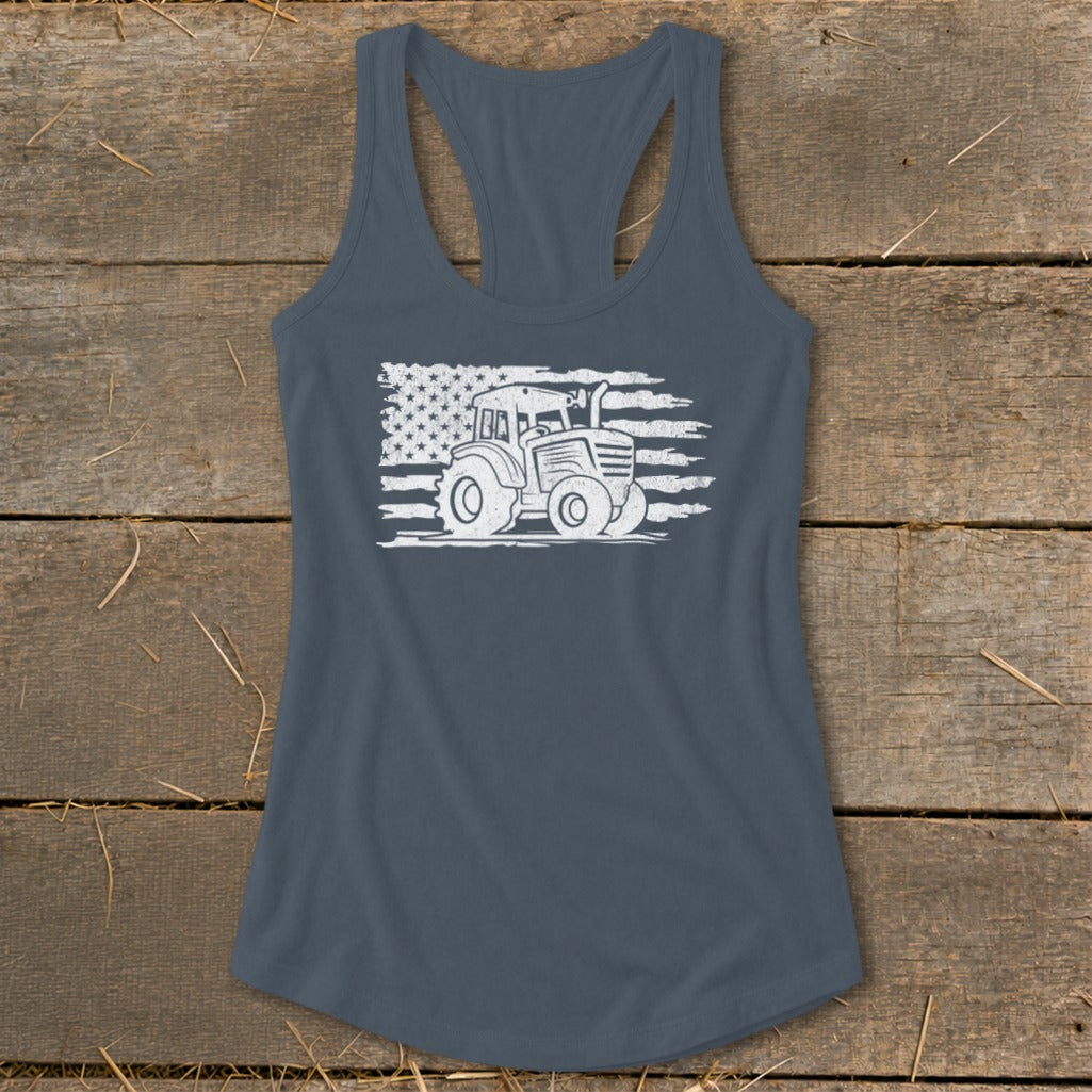 White tractor graphic on distressed American flag print on a dark grey racerback tank top.