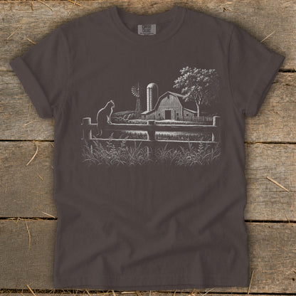 T-shirt with a sketch of a cat on a fence in front of a barn and windmill.