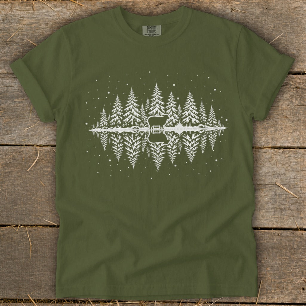 Green t-shirt with white graphic of sheep and pine trees reflected in water.