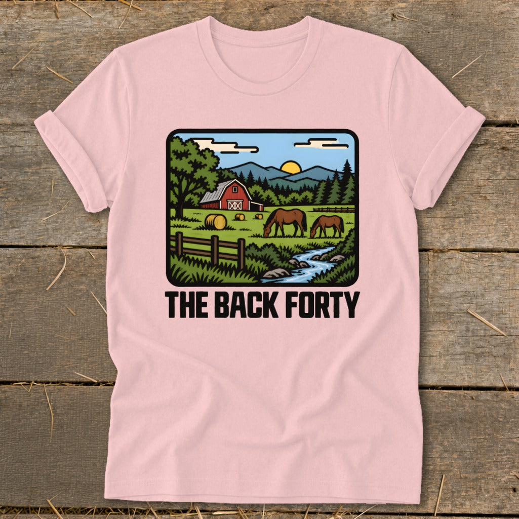 A light pink t-shirt with a vintage-style country graphic featuring a red barn, horses, and the text The Back Forty.