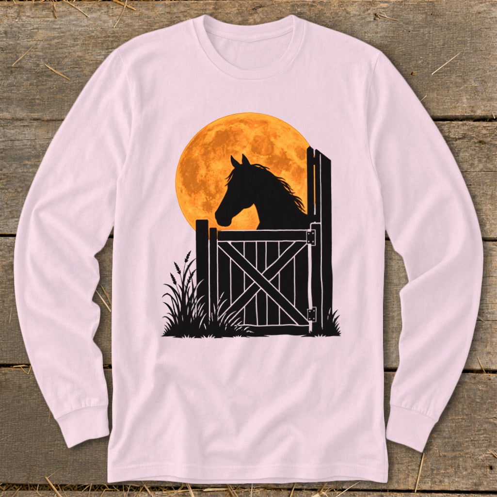 Light pink long-sleeve t-shirt featuring a black silhouette of a horse looking over a gate against a large orange moon.