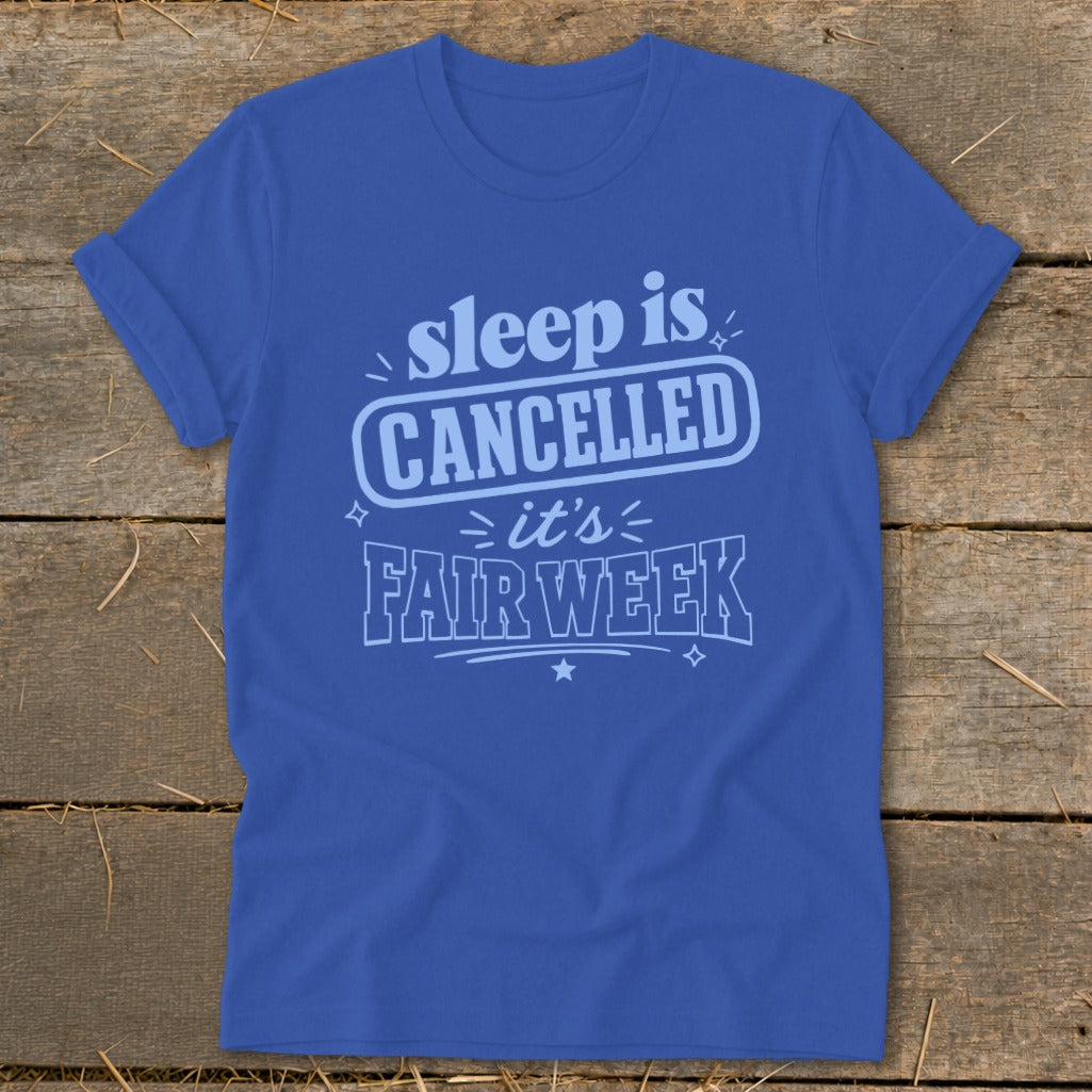 Blue t-shirt with "sleep is CANCELLED it's FAIR WEEK" text design.