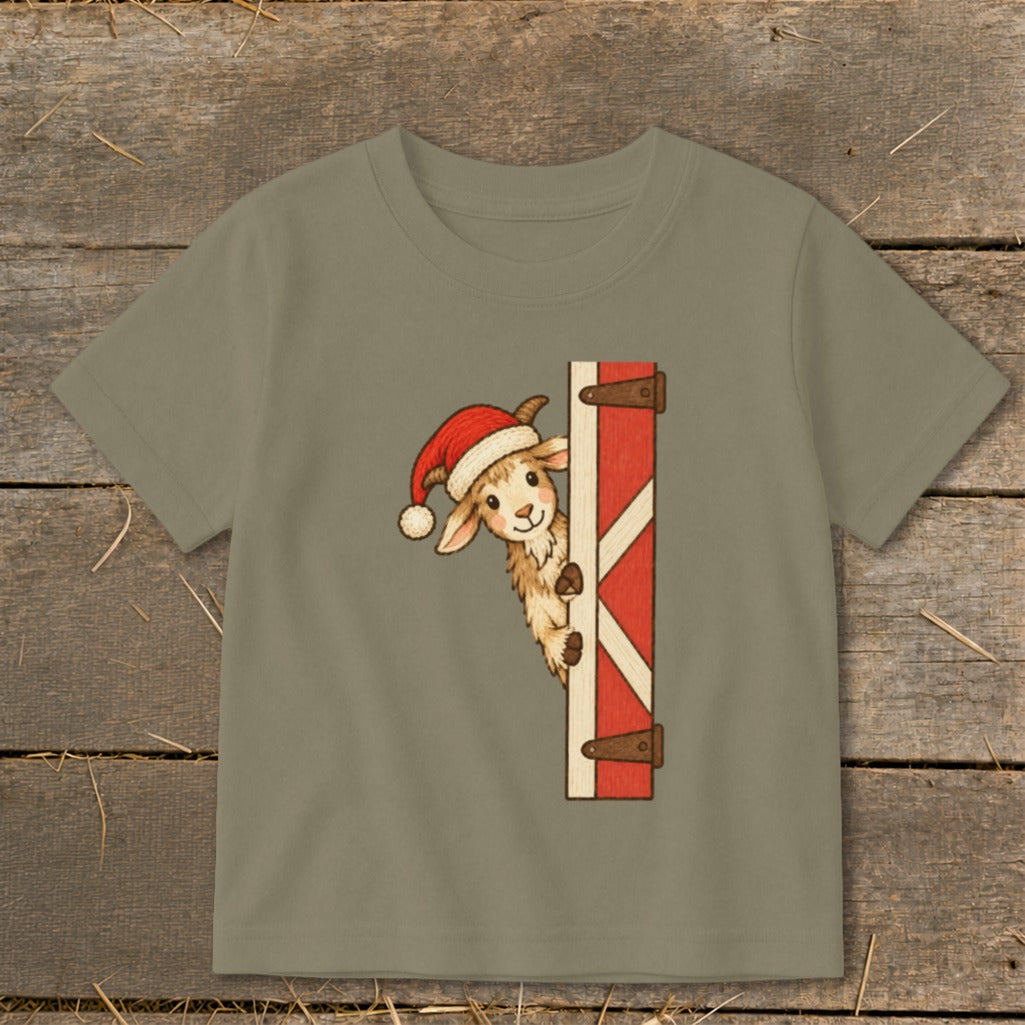 Goat in Santa hat peeking from behind a barn door.