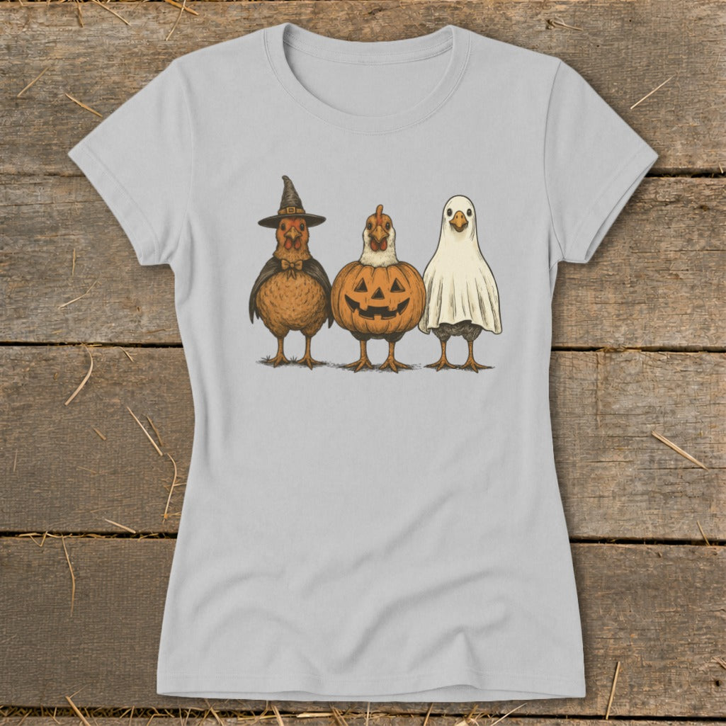 Three chickens dressed as Halloween characters: witch, pumpkin, and ghost.