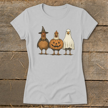 Three chickens dressed as Halloween characters: witch, pumpkin, and ghost.