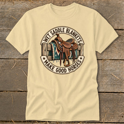 Tan t-shirt with a circular graphic of a western saddle on a blanket over a fence.