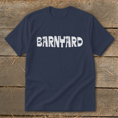 A dark blue crewneck t-shirt with the word BARNYARD printed in distressed white text across the chest, displayed flat on a wooden background.