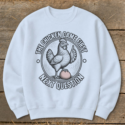 White sweatshirt with "The chicken came first. Next question." text and chicken graphic.
