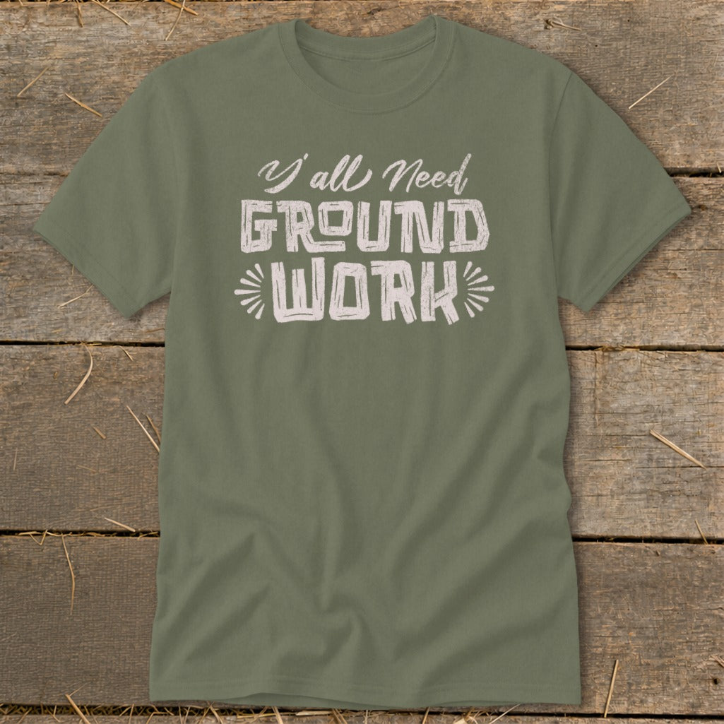 Olive green t-shirt with white text reading "Y'all Need GROUND WORK".