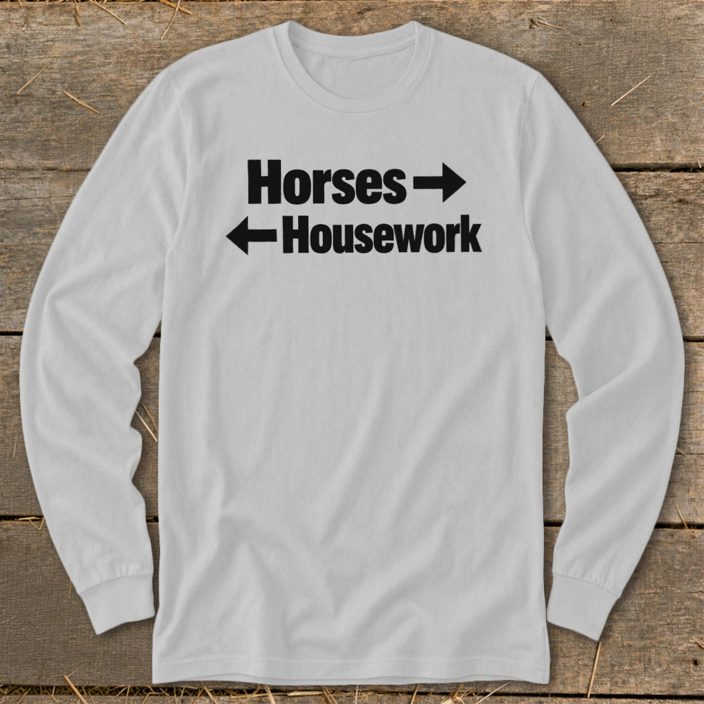 A light gray long-sleeve t-shirt with black text that reads Horses pointing right and Housework pointing left.