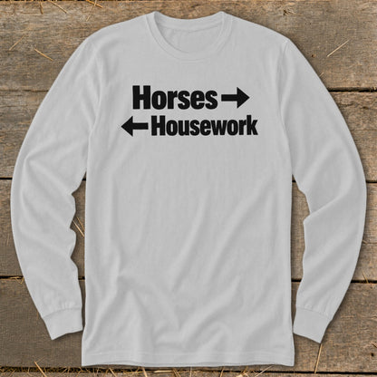 A light gray long-sleeve t-shirt with black text that reads Horses pointing right and Housework pointing left.