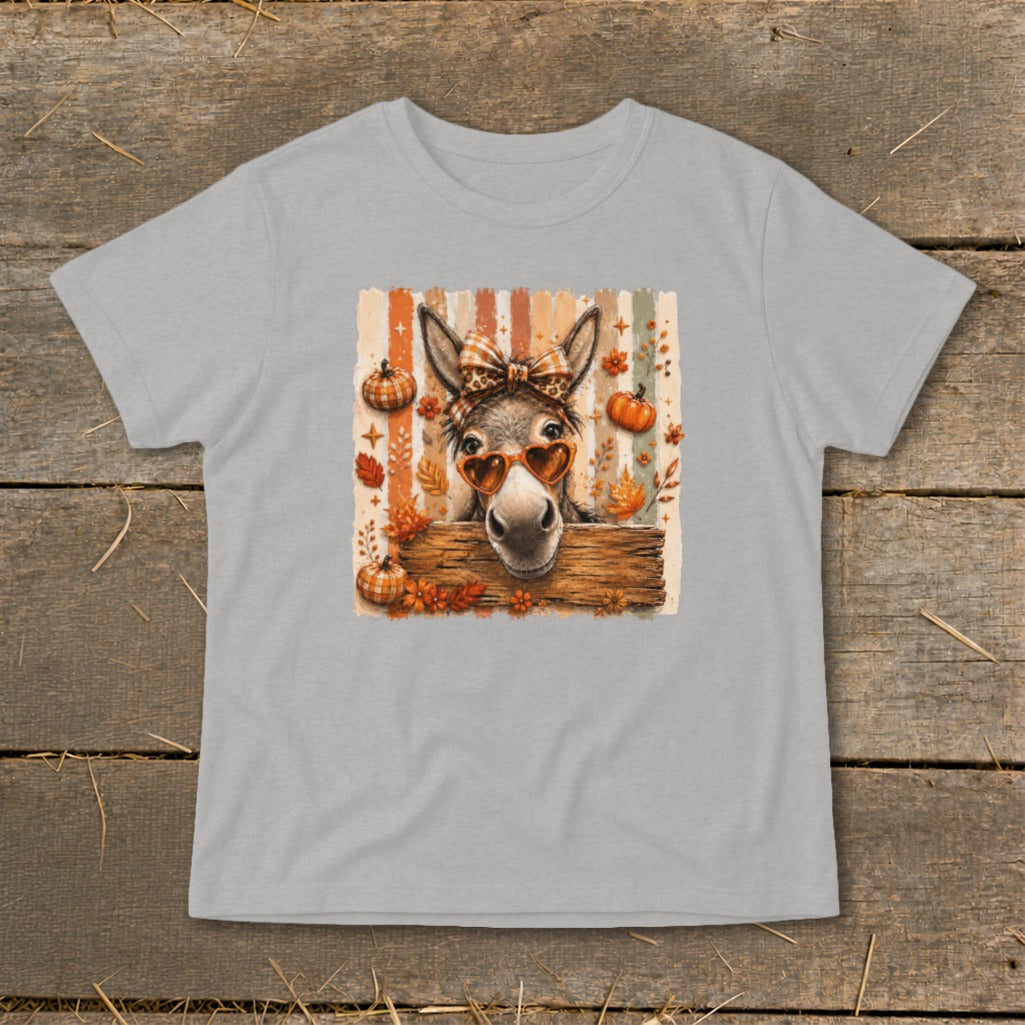 Donkey wearing heart sunglasses and bow, surrounded by pumpkins and fall leaves.