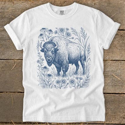 White t-shirt with a blue ink drawing of a bison surrounded by wildflowers.