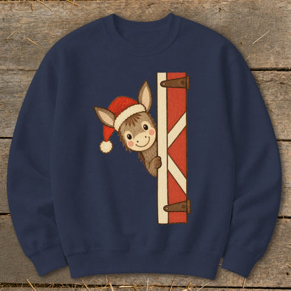 Navy sweatshirt with a smiling donkey wearing a Santa hat peeking from behind a red barn door.