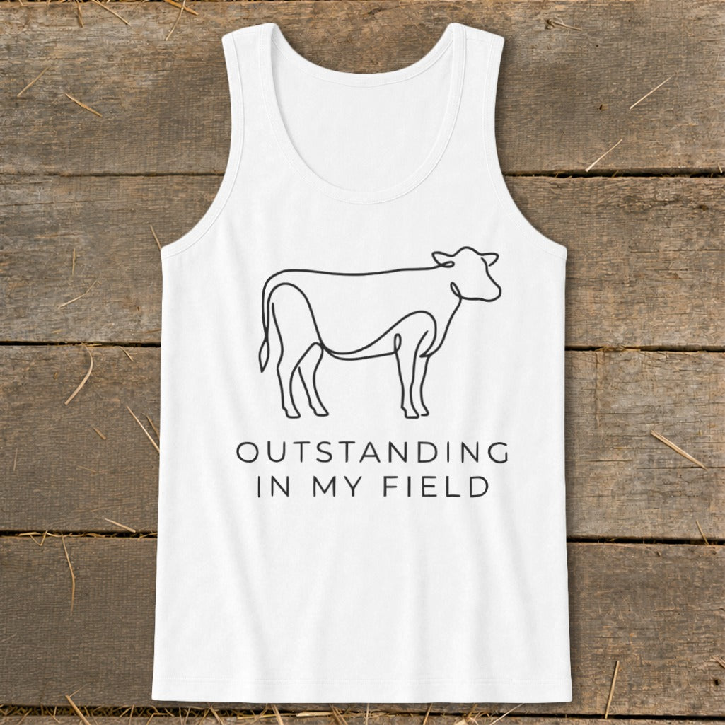 White tank top with black line drawing of a cow and text "OUTSTANDING IN MY FIELD".