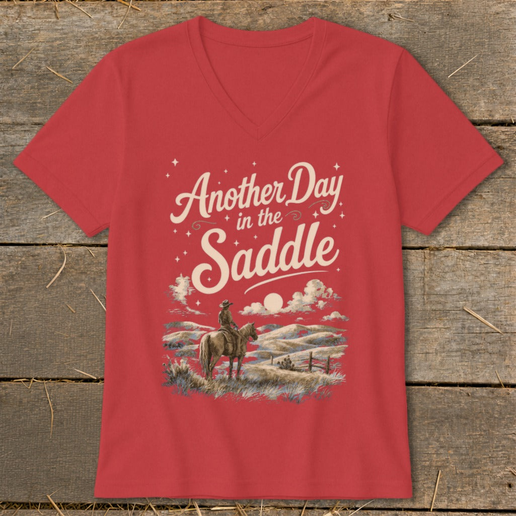 Red v-neck t-shirt with graphic of cowboy on horse and text "Another Day in the Saddle".