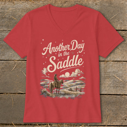 Red v-neck t-shirt with graphic of cowboy on horse and text "Another Day in the Saddle".