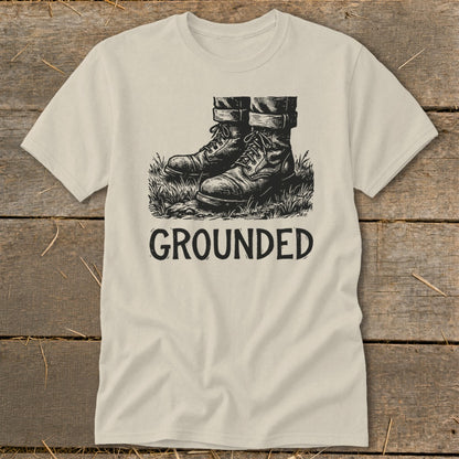 T-shirt with sketch of boots in grass and the word GROUNDED.