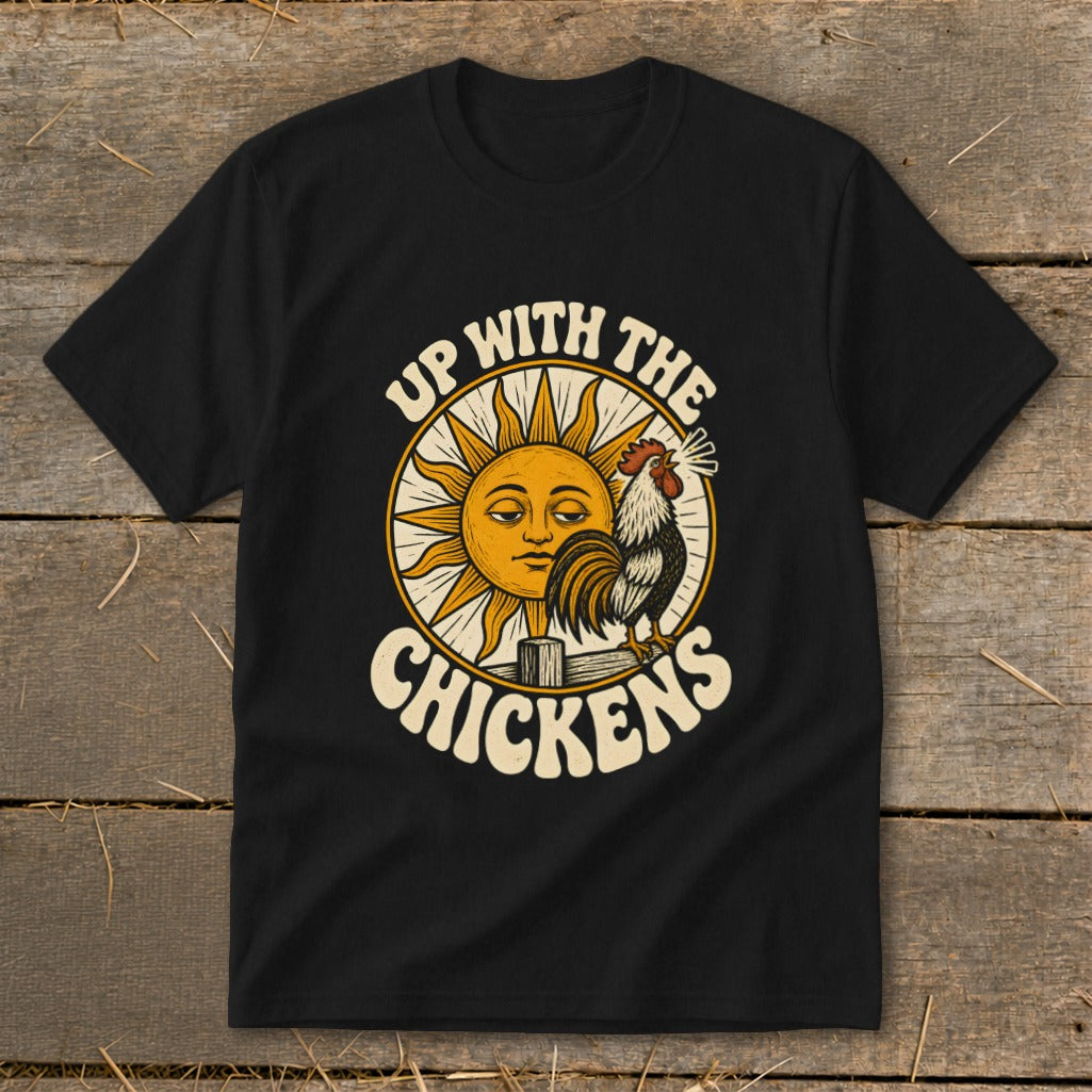 A black t-shirt features a vintage-style graphic of a rooster crowing before a sun with the text UP WITH THE CHICKENS.