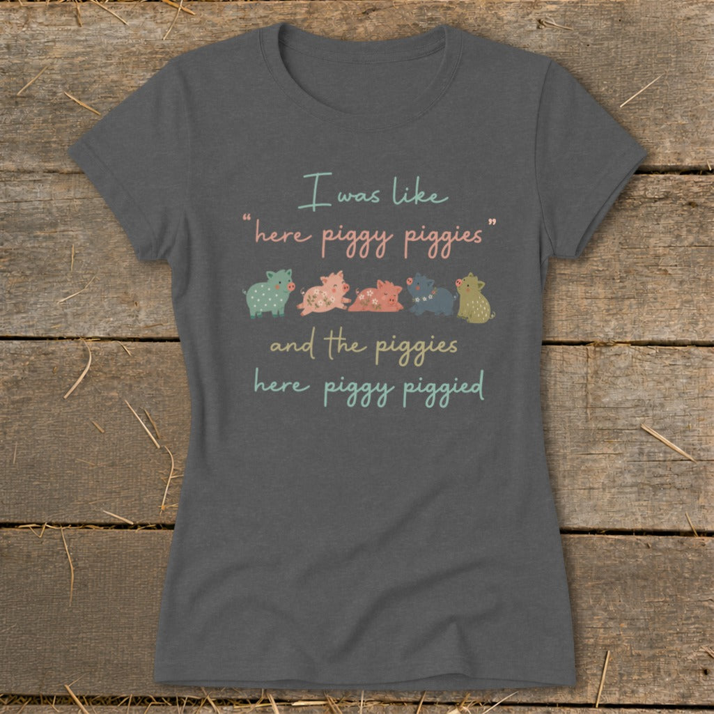 T-shirt with text "I was like 'here piggy piggies' and the piggies here piggy piggied" and row of pigs.
