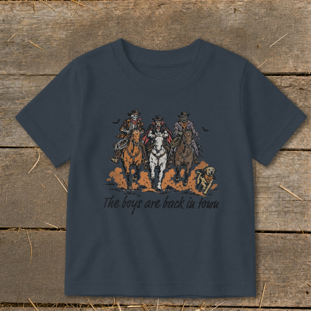Skeleton, vampire, and zombie cowboys ride horses with a dog, text reads "The boys are back in town."