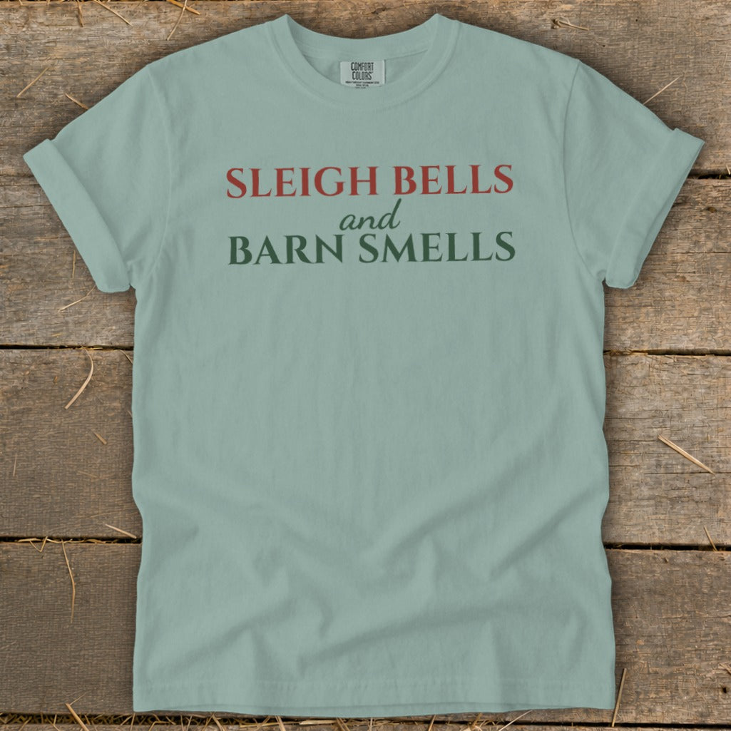 Light blue t-shirt with red and green text reading "Sleigh Bells and Barn Smells".
