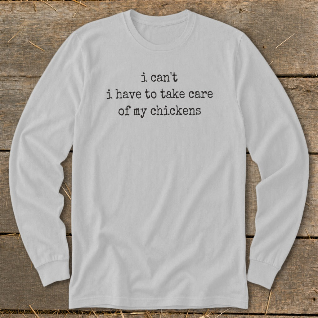 White long-sleeve t-shirt with black text that says "i can't i have to take care of my chickens".