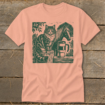 Linocut print of a cat, horse, and mug on a peach t-shirt.