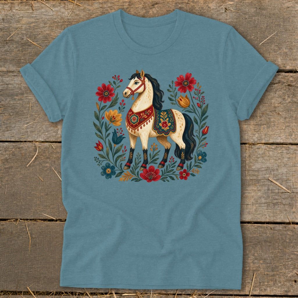 Blue t-shirt with a cream horse surrounded by colorful flowers and foliage.