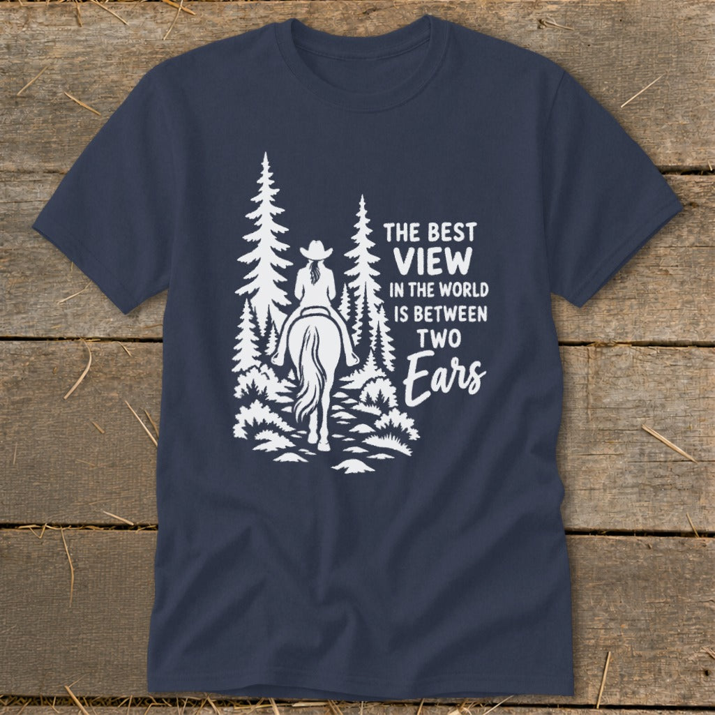 A navy blue t-shirt featuring a white graphic of a horseback rider and text reading The Best View In The World Is Between Two Ears.