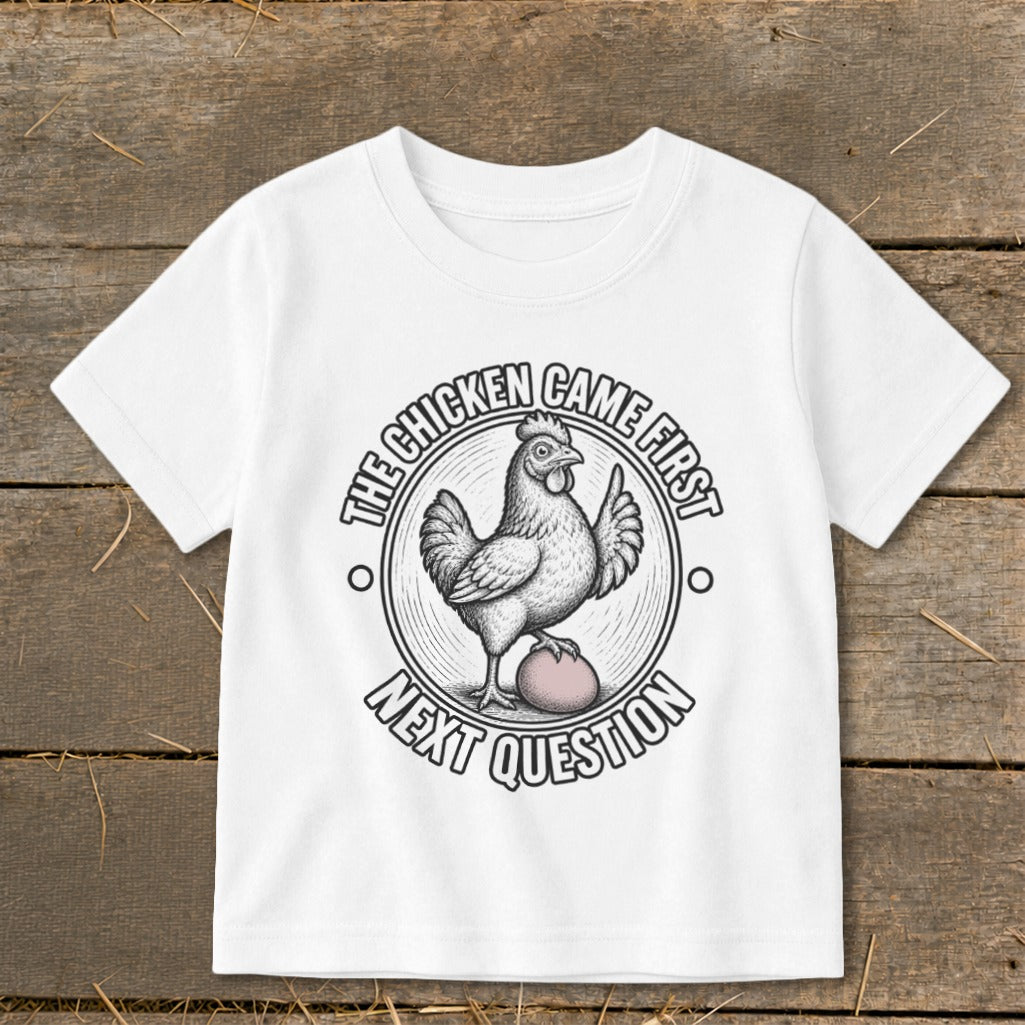 White t-shirt with a circular graphic featuring a chicken and an egg, with text.
