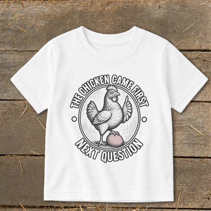 White t-shirt with a circular graphic featuring a chicken and an egg, with text.