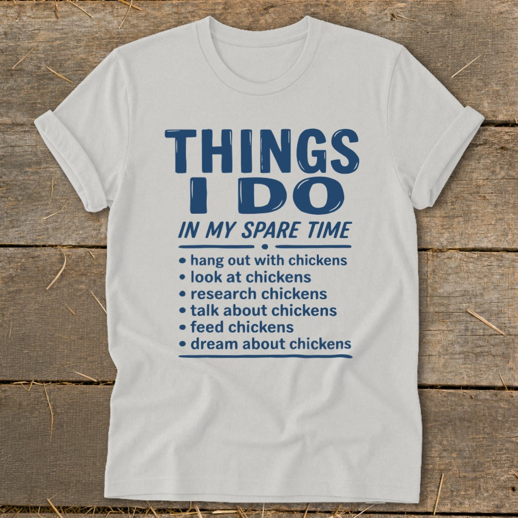 White t-shirt with blue text listing "Things I Do In My Spare Time" with chicken-related activities.