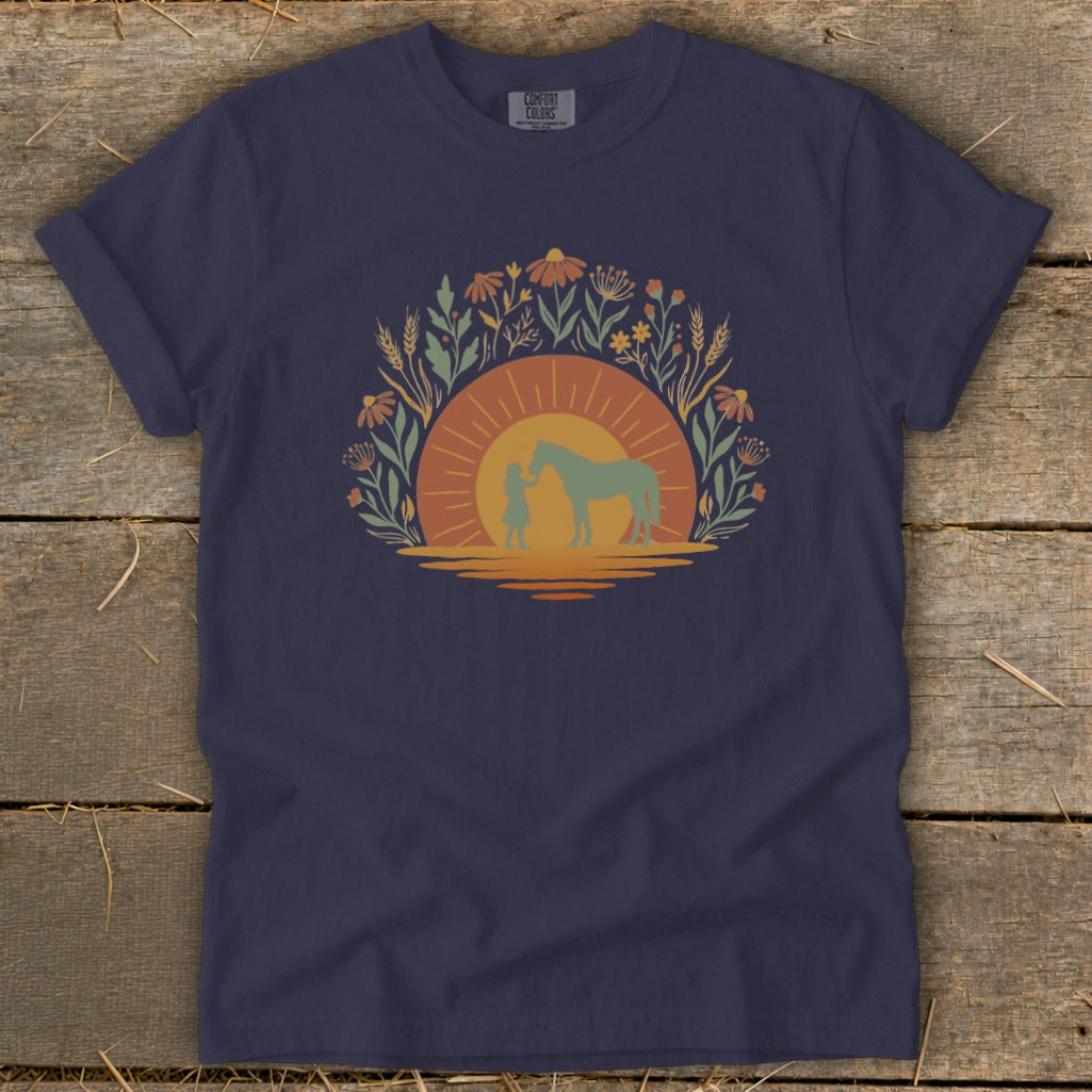 Navy t-shirt with a sunset graphic of a child and horse surrounded by wildflowers.