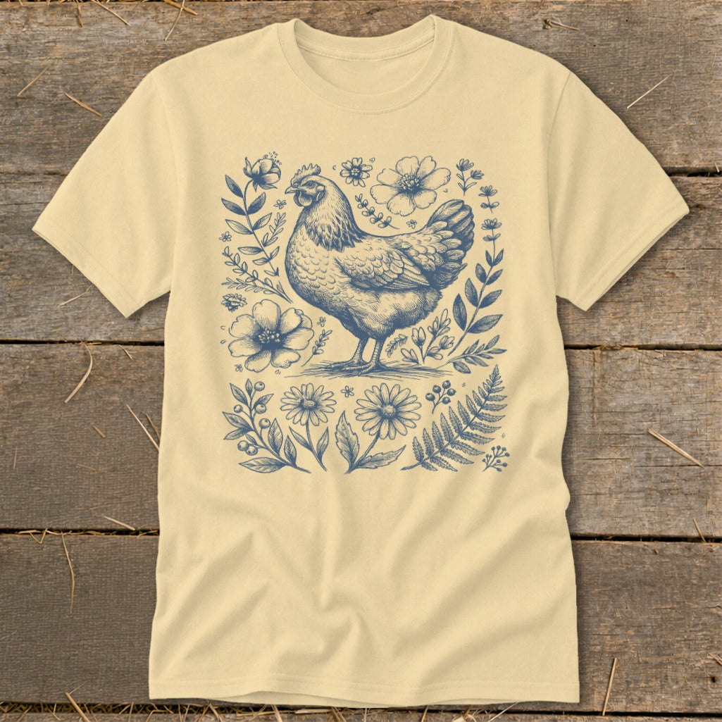 Cream t-shirt with a blue ink drawing of a hen surrounded by floral and foliage elements.