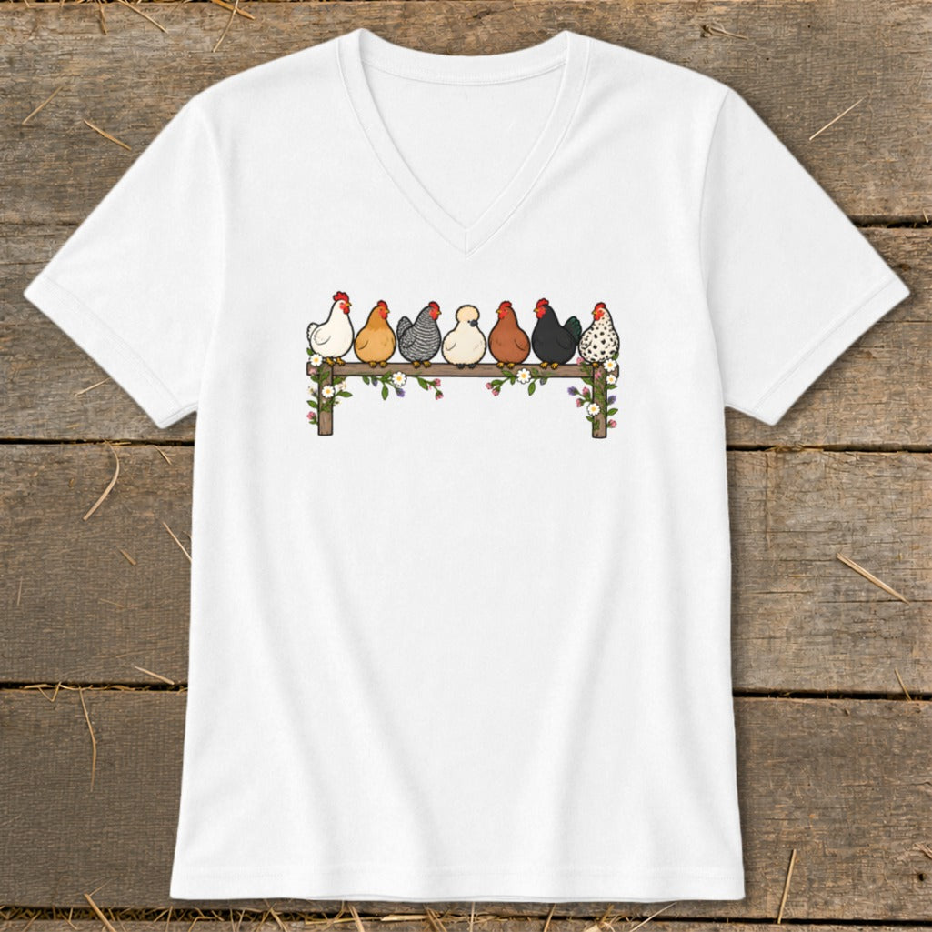 White V-neck t-shirt featuring a cartoon illustration of seven colorful chickens perched on a wooden fence.