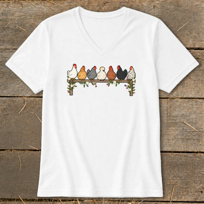 White V-neck t-shirt featuring a cartoon illustration of seven colorful chickens perched on a wooden fence.