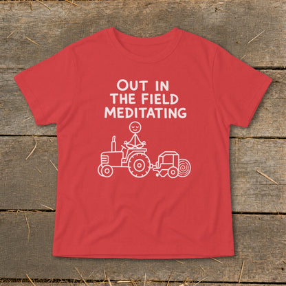 Red t-shirt with white text and graphic of stick figure meditating on a tractor baling hay.