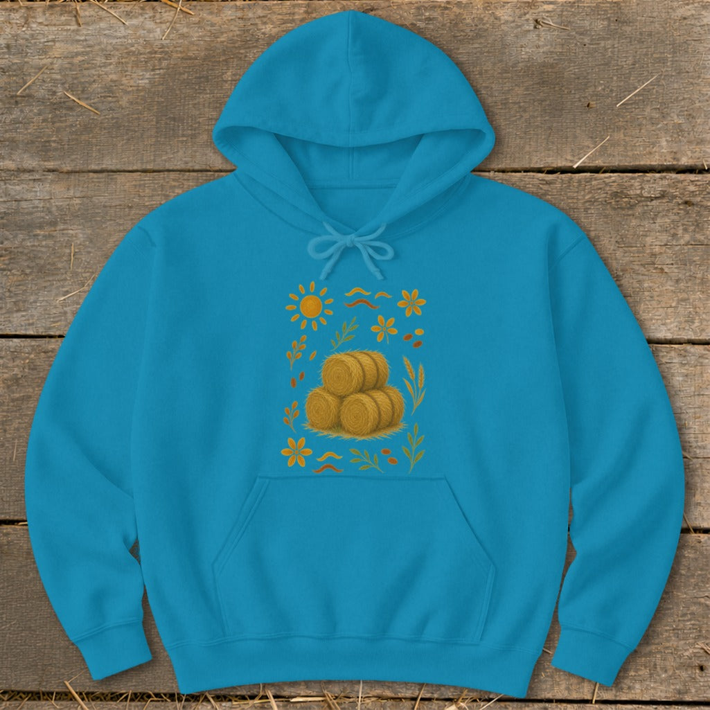 Teal hoodie with stacked hay bales and autumnal floral design.