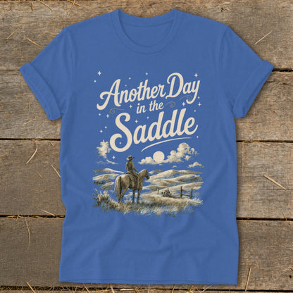 Blue t-shirt with "Another Day in the Saddle" text and cowboy on horseback graphic.