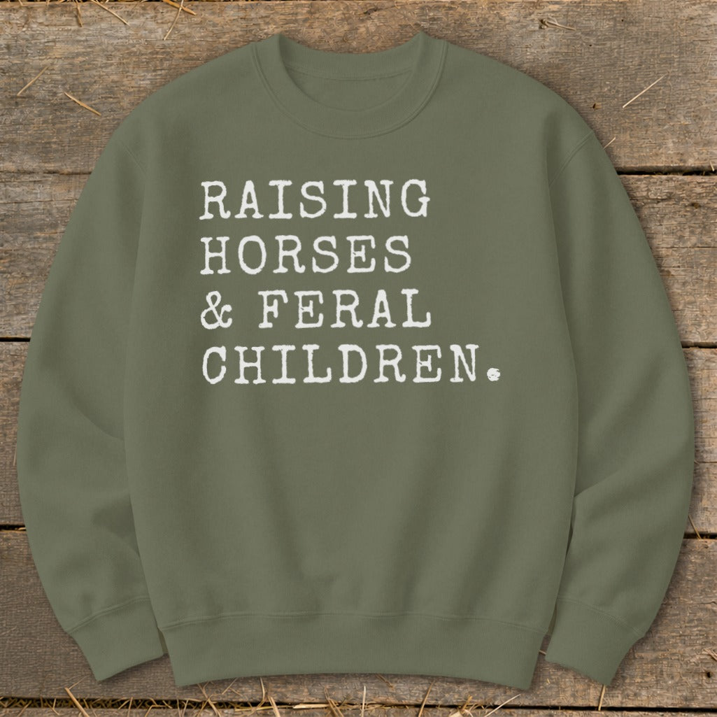 Olive green sweatshirt with white text reading "RAISING HORSES & FERAL CHILDREN."