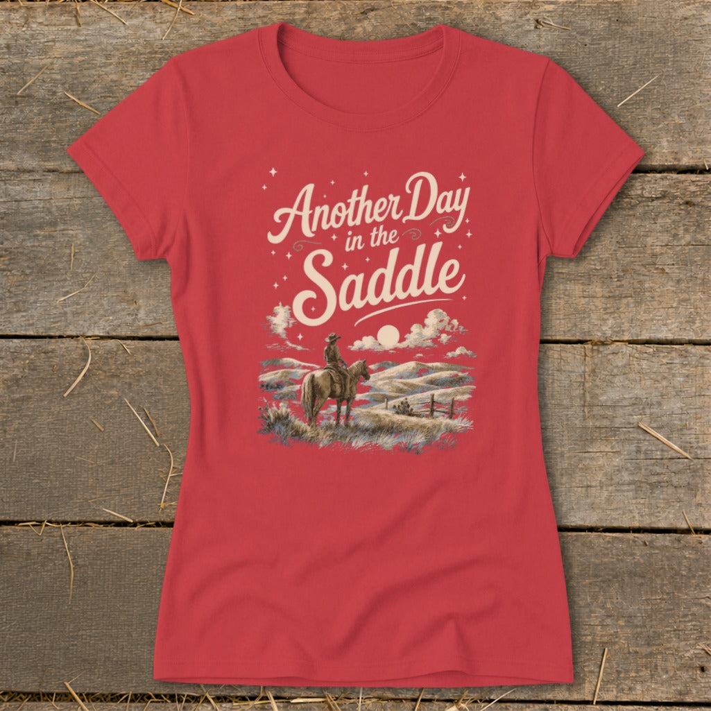 Red t-shirt with "Another Day in the Saddle" graphic and cowboy on horseback.